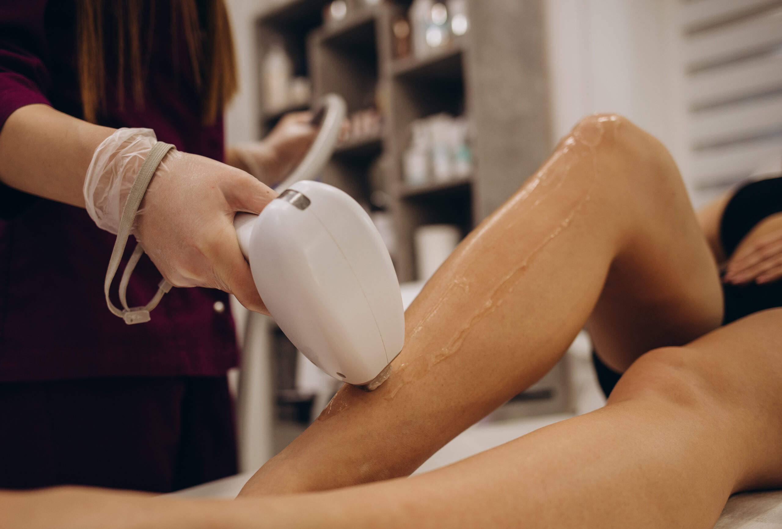 master makes the girl's legs a laser hair removal procedure